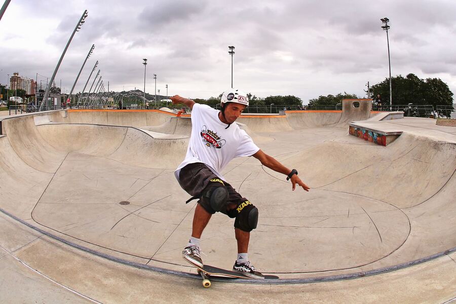 Skatista fazendo linha no bowl da pista de concreto