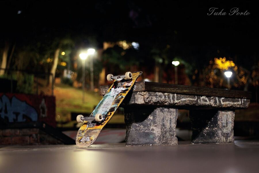 O skate no banco da praça, sob os postes